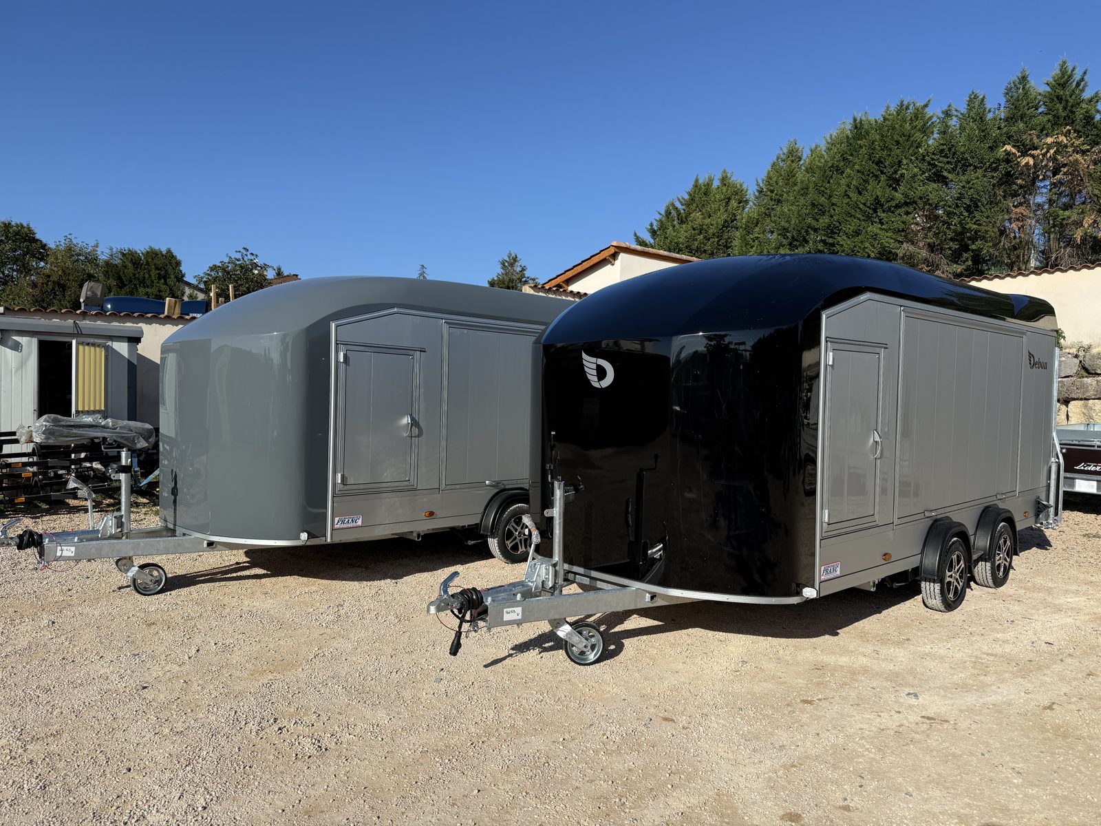 Deux porte-voitures fermés Debon Roadster 1000 Pro, gris et noir, en exposition à Limonest – Remorques Franc Lyon