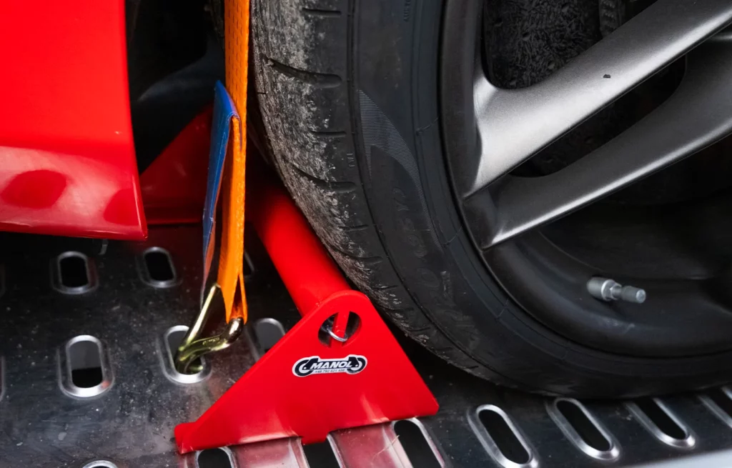 Cale de roue rouge et sangle d’arrimage pour bloquer la voiture